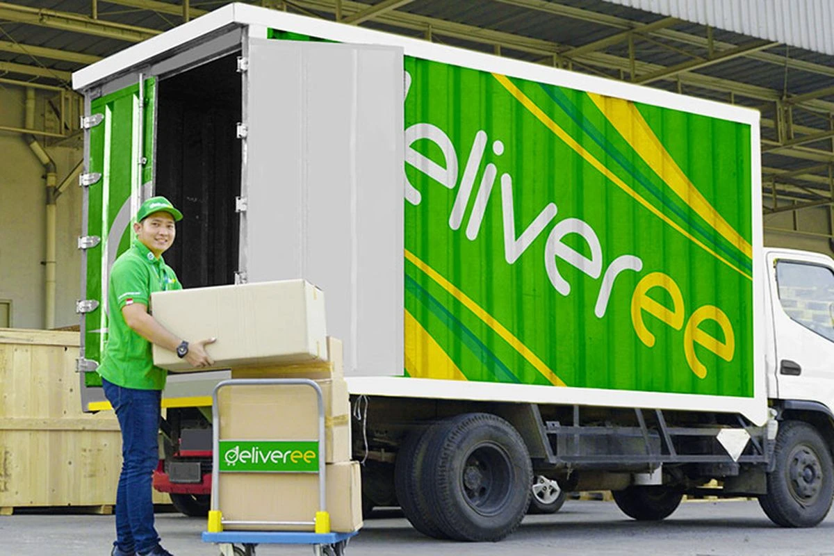 Deliveree driver loading packages beside a branded delivery truck